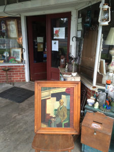 Painting of Tim Drinkwater in 1952 in front of store as it appears today in 2016